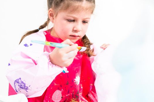 Little girl working on her art project for distance learning at home during COVID-19 pendemic.