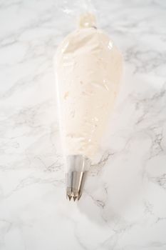 Peppermint buttercream frosting in a piping bag with a jumbo metal piping tip.