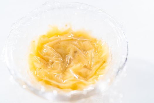 Mashed overripe banana in a glass mixing bowl.