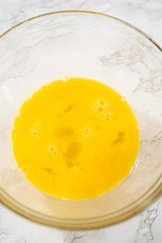 Mixing ingredients in a large glass mixing bowl to bake chocolate peppermint cupcakes.