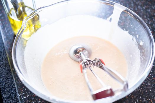 Pancakes batter on a kefir base in a glass mixing bowl.