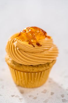 Freshly baked dulce de leche cupcakes on a kitchen counter.