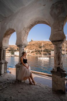 Side view portrait of a relaxed woman breathing fresh air at the seaside. She stands near the old column