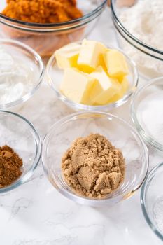 Measured ingredients in a glass mixing bowl to bake pumpkin bunt cake.