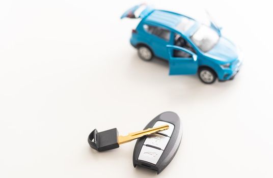 Car key and toy car. Automobile security accessories.
