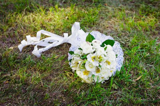 Bridal wedding bouquet of flowers. Wedding bouquet of yellow and white roses lying on a grass