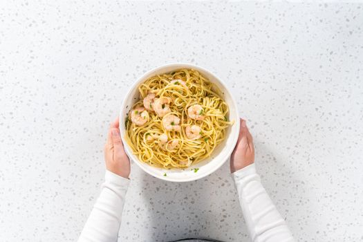 Flat lay. Serving homemade shrimp scampi with linguine pasta garnished with fresh parsley.