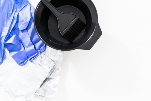Black hair color dye kit with mixing bowl on a white background.