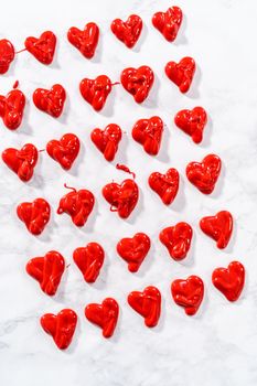 Piping melted chocolate from piping back over the parchment paper to make a chocolate heart.