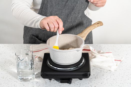 Caramelizing sugar in a saucepan to make caramel cupcake toppers.