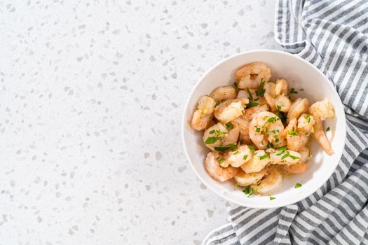 Shrimp scampi garnish with fresh parsley in a bowl.