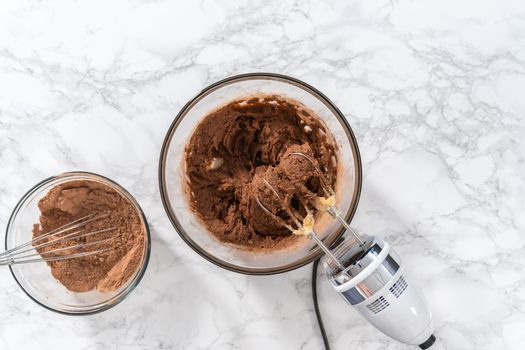 Flat lay. Mixing ingredients with a hand mixer to bake chocolate cookies with chocolate hearts for Valentine's Day.