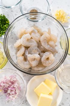 Measured ingredients in glass mixing bowls to make shrimp scampi with linguine pasta.
