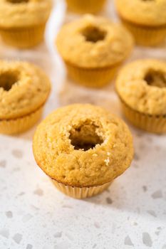 Filling cupcakes with caramel to make dulce de leche cupcakes.