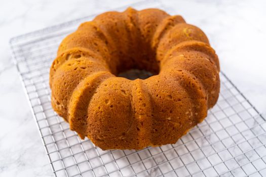 Cooling freshly baked pumpkin bunt cake on a kitchen counter.