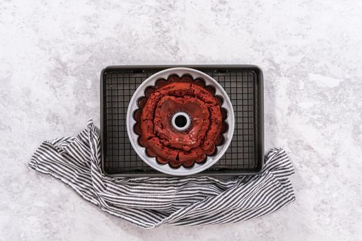 Flat lay. Cooling freshly baked red velvet bundt cake on a kitchen drying rack.