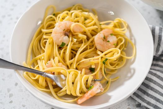 Serving homemade shrimp scampi with linguine pasta garnished with fresh parsley.