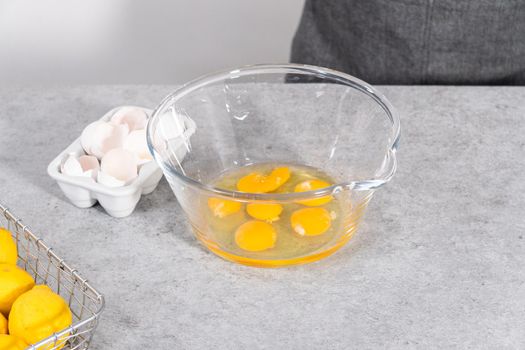 Mixing ingredients in a glass mixing bowl to prepare lemon cranberry bundt cake.
