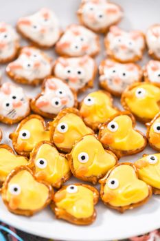 Easter chocolate-covered pretzel bunnies and ducklings on a white serving plate for the Easter table.