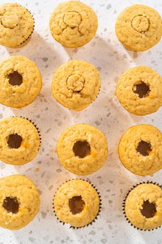 Filling cupcakes with caramel to make dulce de leche cupcakes.