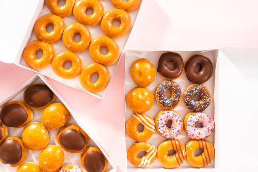 Flat lay. Variety of store-bought doughnuts in a white paper box.