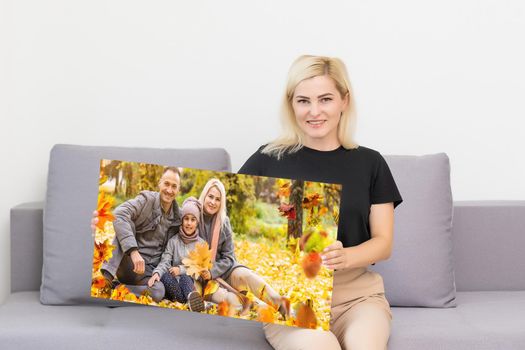 Canvas print with gallery wrap. woman hangs autumn photography, photocanvas.