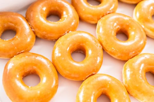 Plain glazed store-bought doughnuts in a white paper box.