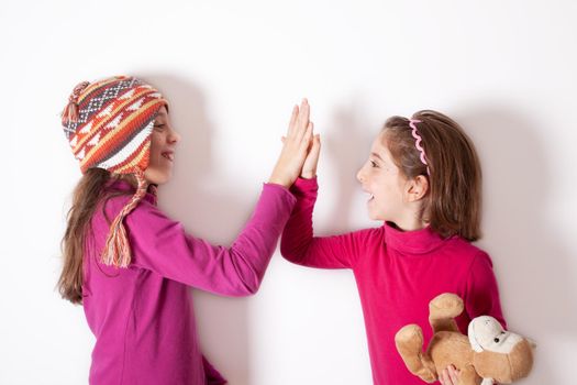 Little sisters giving high five on white background