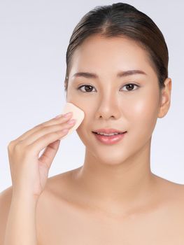 Gorgeous woman applying her cheek with dry powder. Portrait of younger with perfect makeup and healthy skin concept.