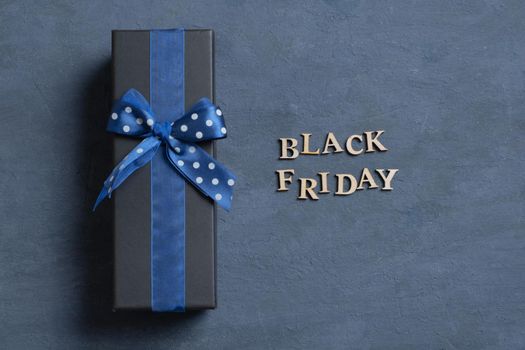 Black Friday text with gift flat lay on dark cement background. Top view.