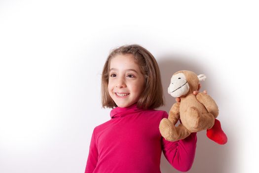 Portrait of cute Little Girl emotional showing her Plush Monkey on white background