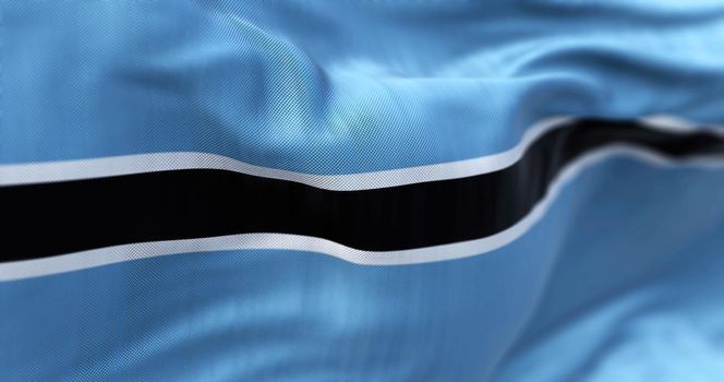 Close-up view of the Botswana national flag waving in the wind. The Republic of Botswana is a country in Southern Africa. Fabric textured background. Selective focus