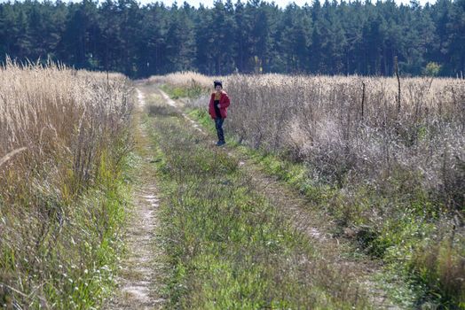 Young boy playing in a field. boy running across the field with his hands in different directions. children fun games. nature leisure with children concept.