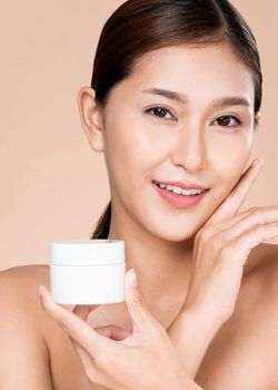 Closeup ardent woman smiling holding mockup product for advertising text place, light grey background. Concept of healthcare for skin, beauty care product for advertising.