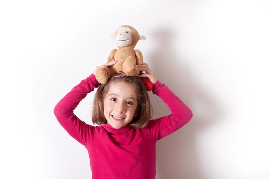 Portrait of cute Little Girl emotional holding a Plush Monkey on white background