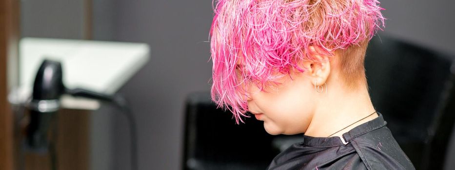 Beautiful young pink haired caucasian woman in the modern hair salon