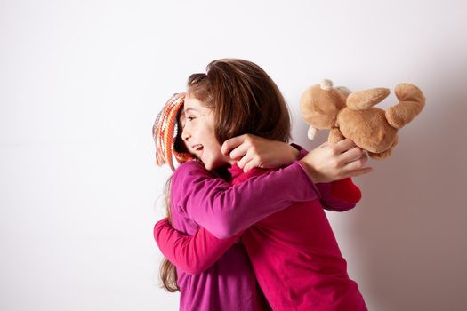 Happy and healthy young little girls hugging and smiling. Best friend kids and children friendship, equality, positive mental health wellness concept