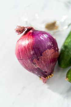 Ingredient to prepare summer cucumber salad with fresh dill and purple onions.