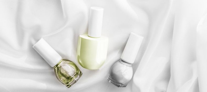 Cosmetic branding, salon and glamour concept - Nail polish bottles on silk background, french manicure products and nailpolish make-up cosmetics for luxury beauty brand and holiday flatlay art design