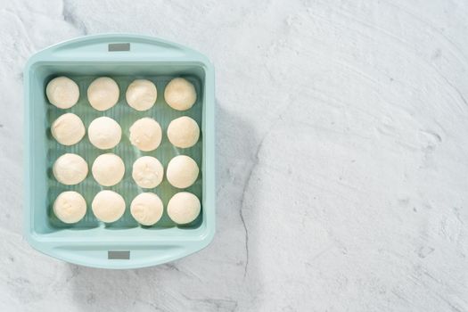 Flat lay. Baking dinner rolls from the premade frozen dough in the baking pan.
