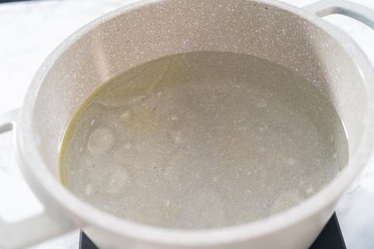 Boiling water in the cooking pot to prepare macaroni and cheese with broccoli.