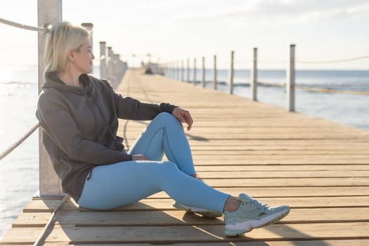 Female tourist walk and chill on wooden bridge as surround sea and beach.