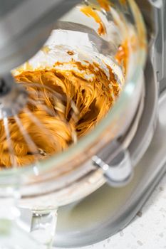 Whipping ingredients in a stand electric mixer to make dulce de leche buttercream frosting.