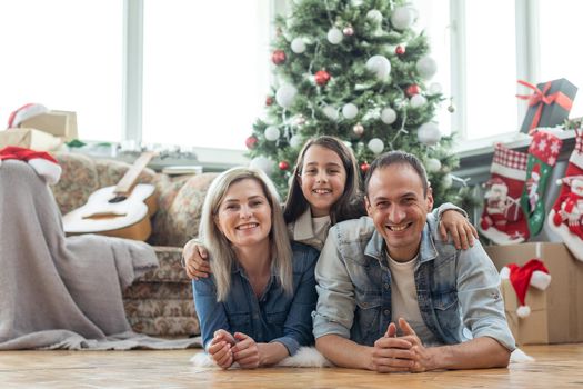 family having fun and playing together near Christmas tree indoors