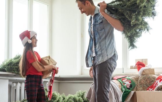 father and daughter install an artificial Christmas tree.