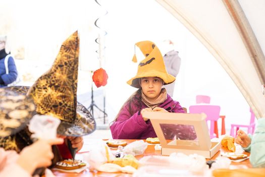 Little girl decorates cookies for Halloween. Children's art project, a craft for children