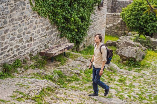Man tourist walks through the old town of Bar in Montenegro. Happy tourist walks in the mountains. Suburbs of the city of Bar, Montenegro, Balkans. Beautiful nature and landscape.