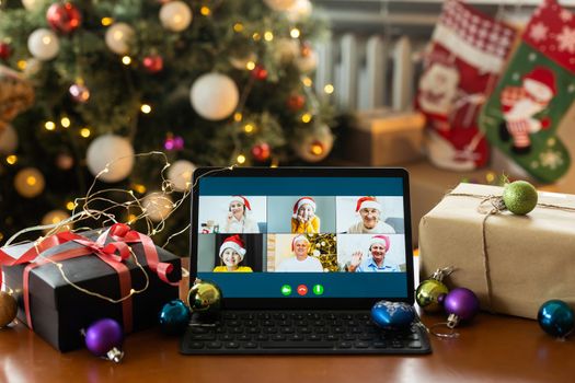 Big family singing christmas song at tablet camera during online video call. Smiling parents and children. Joyful family congratulating relatives with happy new year online.