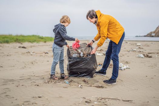 Dad and son in gloves cleaning up the beach pick up plastic bags that pollute sea. Natural education of children. Problem of spilled rubbish trash garbage on the beach sand caused by man-made.