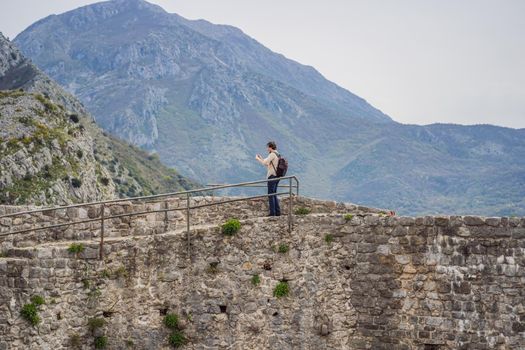 Man tourist walks through the old town of Bar in Montenegro. Happy tourist walks in the mountains. Suburbs of the city of Bar, Montenegro, Balkans. Beautiful nature and landscape.